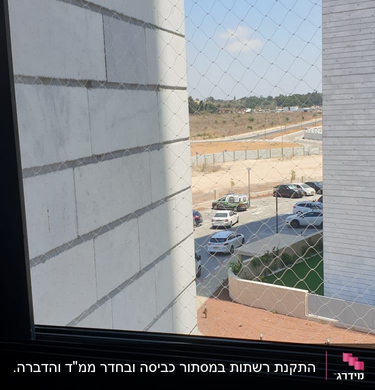 רשת נגד יונים מותקנת על חלון בניין